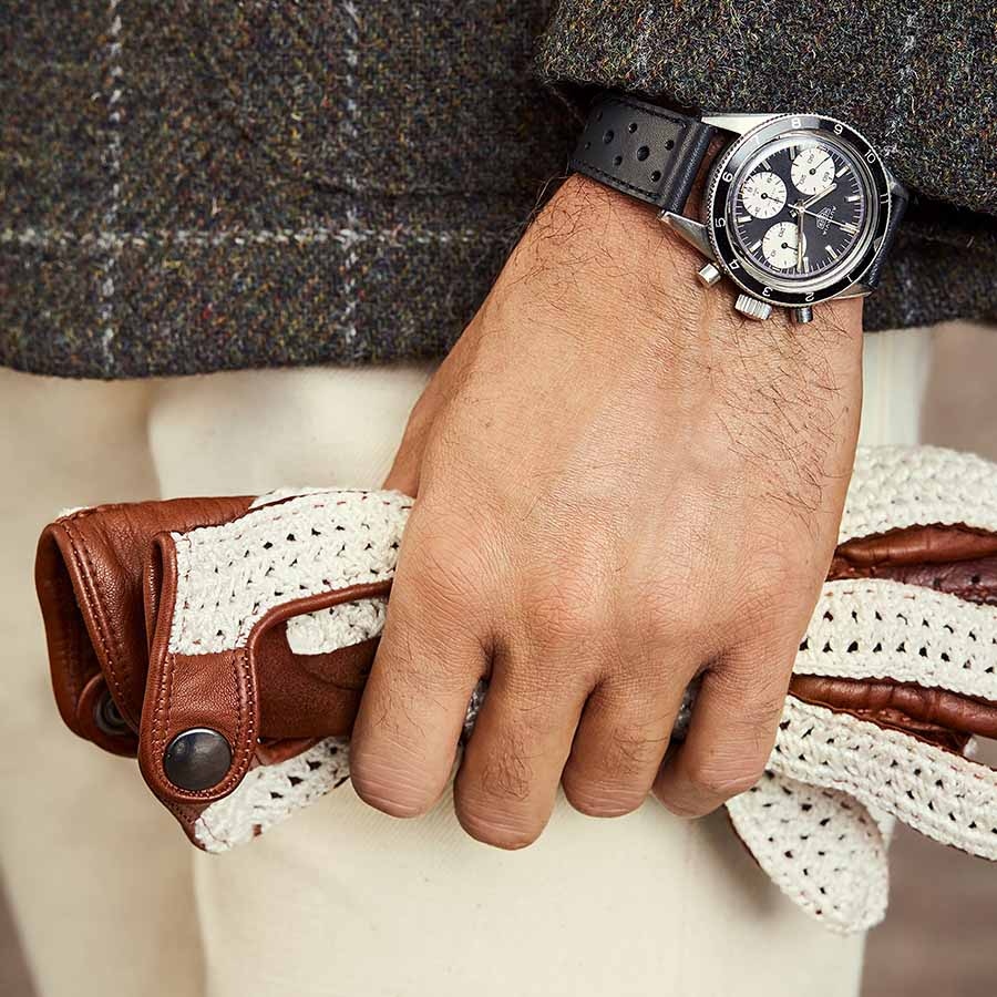 Details of Tag Heuer's 1966 chronograph featuring Omega SRL's ivory crochet and brown leather driving gloves.