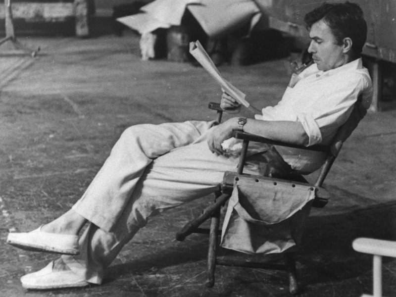 Actor James Mason smoking a pipe while reading a script on the set of Julius Caesar in 1952.