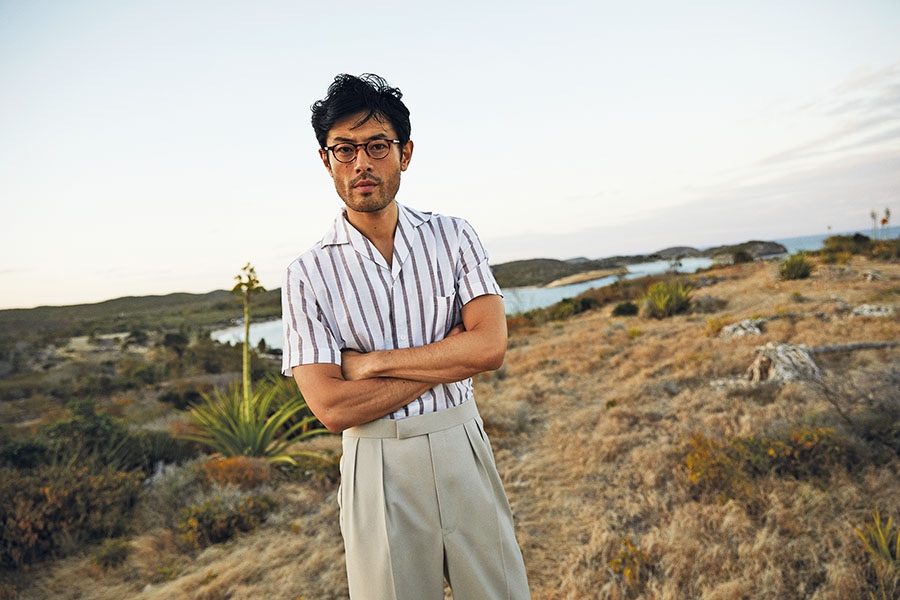 White and brown cotton revere collar shirt, Lardini at The Rake; beige wool gabardine fishtail trouser; Edward Sexton at The Rake; tortoiseshell acetate glasses; C.W. Dixey & Son.