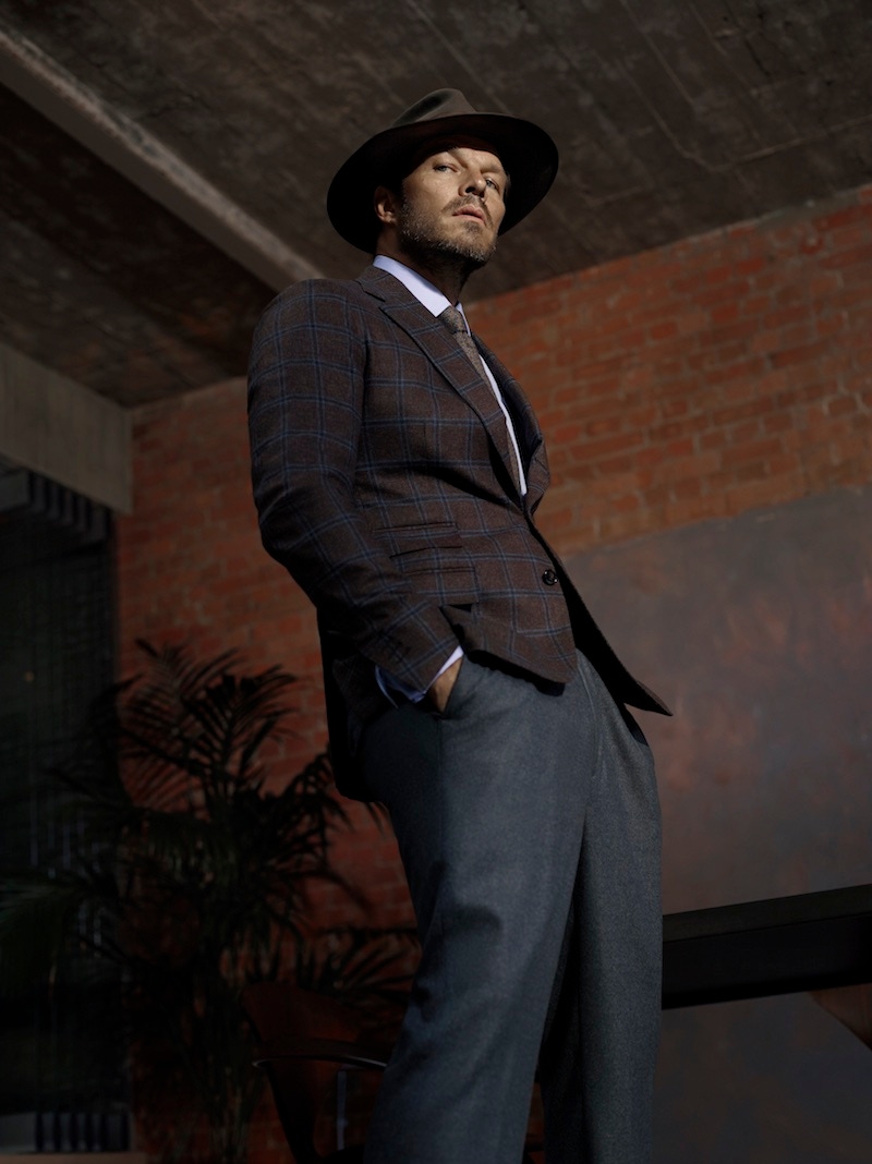 Brown/blue cashmere blend windowpane check jacket, De Petrillo; blue classic cotton shirt, Turnbull & Asser; brown patterned cashmere tie, Emma Willis; charcoal grey flannel Manny trousers, Rubinacci; Bancroft solid silver cufflinks, Alice Made This; brown St. James fedora, Lock & Co.