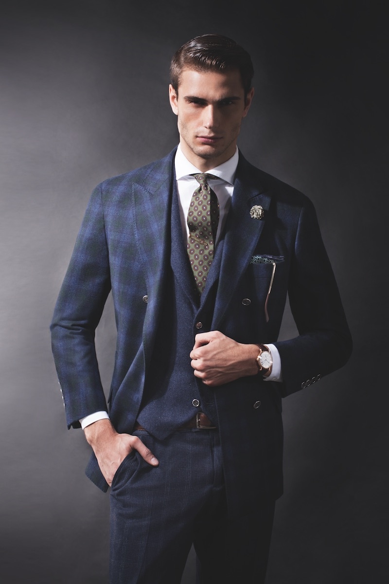 Blue and green tartan wool-cashmere double-breasted sport coat, blue cashmere single-breasted vest, white spread-collar cotton shirt, blue and black Prince of Wales-check trousers, brown leather belt, and blue and green geometric-pattern silk pocket square, all Brunello Cucinelli; Classique ref. 5277BR timepiece in 18k-rose-gold case and brown alligator-leather strap, Brequet. Green, maroon and yellow floral wool tie, Polo Ralph Lauren; blue and white cotton floral boutonniere, Q Menswear; gold vintage aviators (all property of The Rake).