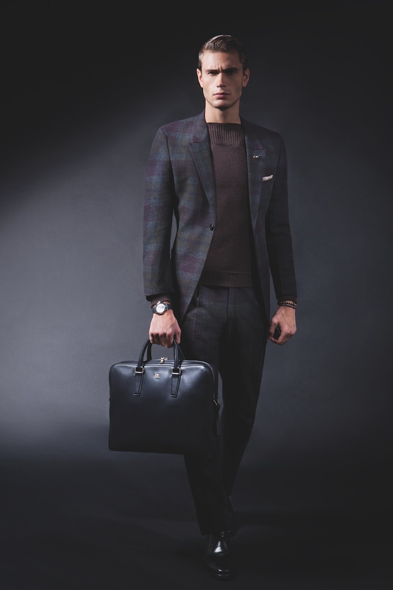 Grey-tone multicoloured tartan wool-polyamide single-breasted two-piece suit, and brown cashmere boat-neck jumper, both Ermenegildo Zegna Couture; brown smoking-pipe sterling-silver boutonniere, and brown quartz-bead bracelet, both Q menswear; brown single-wrap Scoubidou leather bracelet with 18k-white-gold clasp, Tateossian (available at Uomo Collezioni); navy leather document bag, Brioni; black leather lace-up shoes, Tod's. Green and brown tartan cotton pocket-square; Galet Micro-Rotor timepiece in 18k-white gold case and grey alligator-leather strap with alcantara lining, Laurent Ferrier (both property of The Rake).