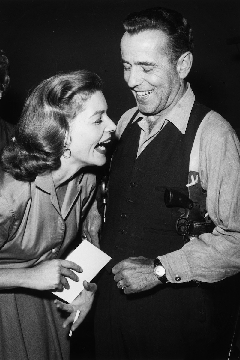 Lauren Bacall and Humphrey Bogart share a joke on the set of the Producers' Showcase television broadcast in 1955.