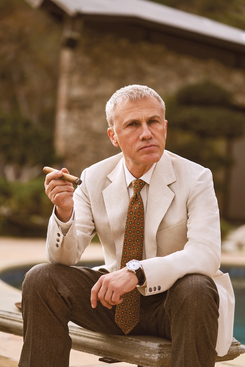 Cream linen herringbone jacket, Hunstman; white cotton shirt, Budd Shirtmaker; brown wool trouser, Lardini; tan silk printed tie, Rubinacci. L.U.C 1937 Classic watch from the L.U.C collection featuring a white dial with roman numerals, COSC-certified chronometer set in stainless steel on a black alligator strap, Chopard.