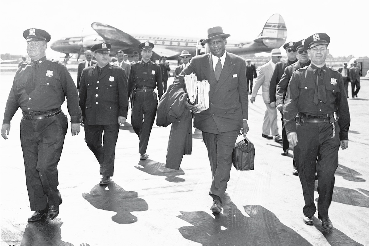 Paul Robeson is escorted by police as he arrives at LaGuardia Field. (Photo by Art Edger/NY Daily News Archive via Getty Images)