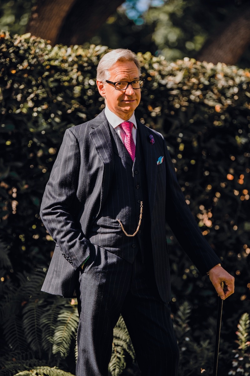 Bespoke pinstripe three-piece navy suit, Anderson & Sheppard; pink party balloon tie and boutonnière, Charvet; white bespoke shirt, Anto of Beverly Hills; pocket-handkerchief, Penrose; eyewear, Prada; antique chain attached to rose-gold pocket-watch, Patek Philippe.