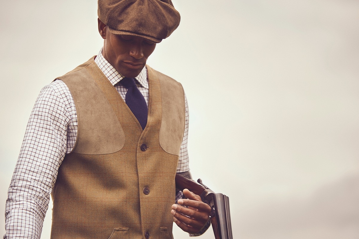 Bembridge tech tweed shooting vest and breeks, Dalby Loden bakerboy cap and Pentire crossknit alpaca shooting sock with light blue garters, all Purdey & Sons; brown and navy Oxford check cotton shirt and navy cashmere tie, Emma Willis; dark brown calfskin Husaren boots, Ludwig Reiter at TheRake.com.