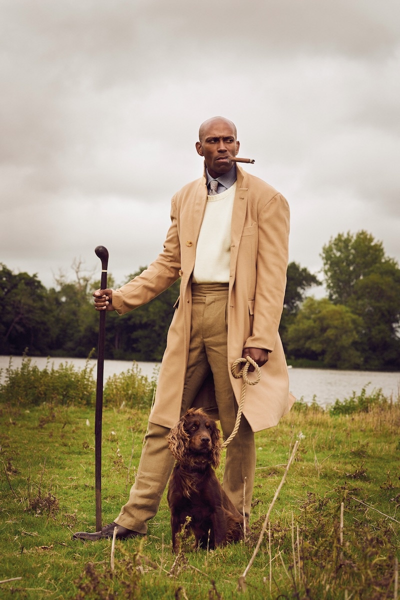 Beige camel wool coat, Dalcuore at TheRake. com; light natural cotton crewneck sweater with saddle shoulder detail, Anderson & Sheppard; blue cashmerello shirt and red POW check silk tie, Purdey & Sons; coffee Irish linen Gurkha trouser, Lucan at TheRake.com; Cotswold brown grain calf leather Bryan boot, George Cleverley; walking stick, property of Alfred Bagge.