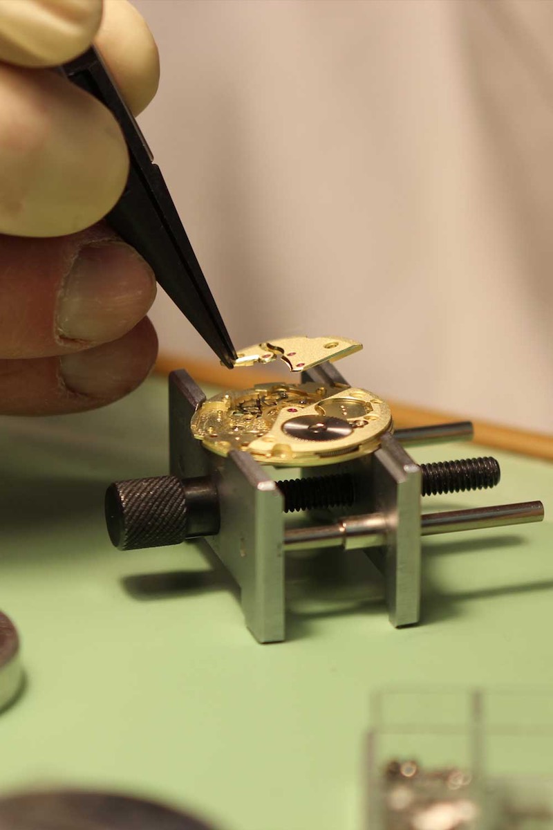 Michiel Holthinrichs gingerly placing a finished bridge onto a movement in the midst of assembly