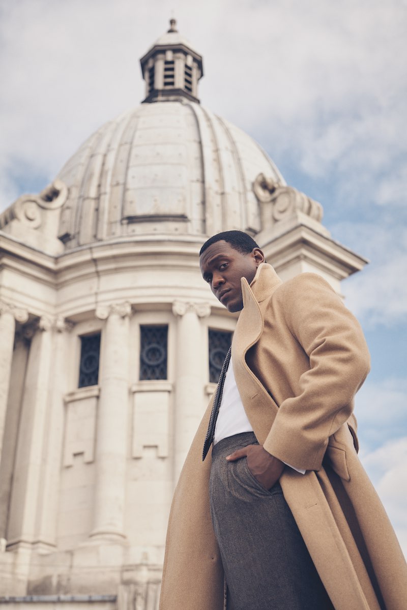 Camel Conrad officer coat in fawn wool, Walker Slater at The Rake; white cotton shirt and brown silk pattern tie, Emma Willis; mid-brown salt and pepper Aleksandar trouser, Kit Blake at The Rake.