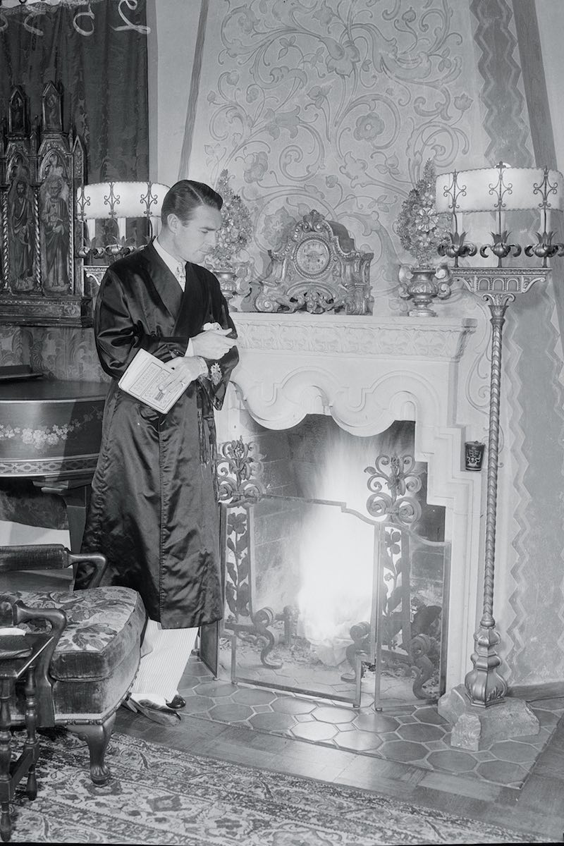 Randolf Scott leaning against fireplace (Photo by � Bettmann/CORBIS/Bettmann Archive/Getty)