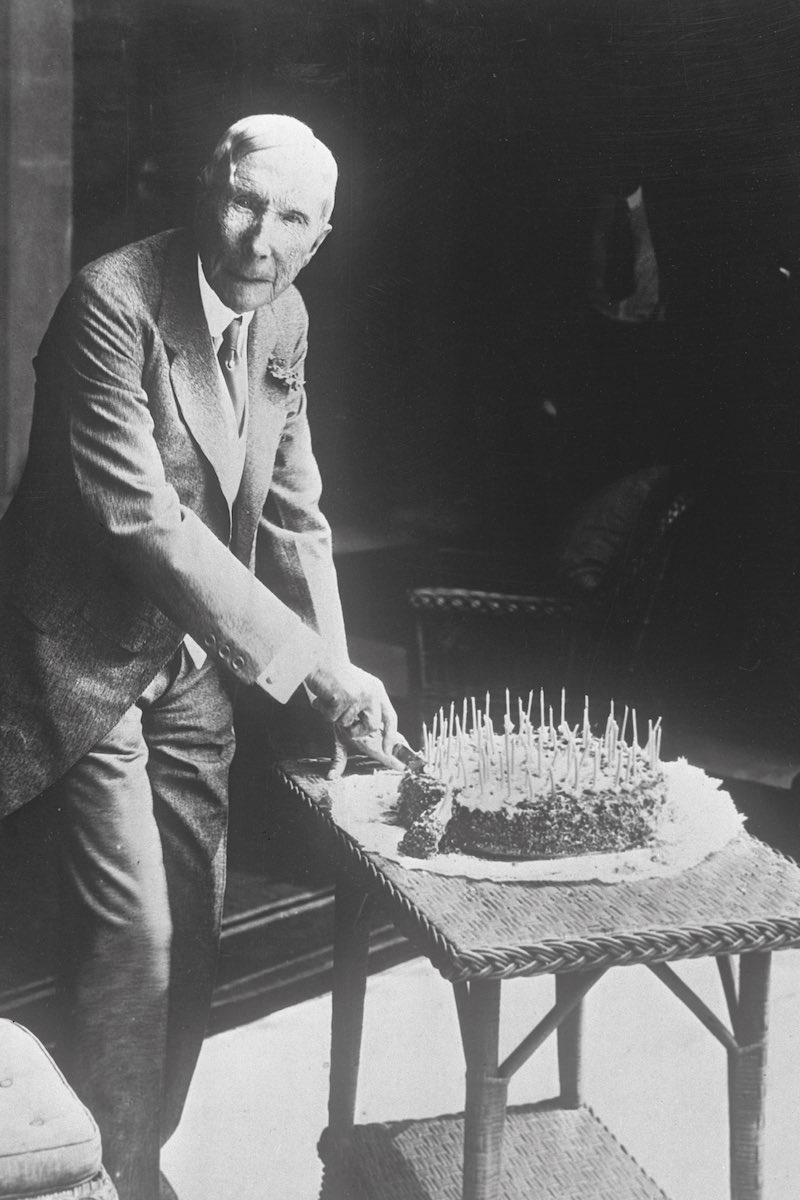 John D. Rockefeller cutting his birthday cake (Photo via Getty)