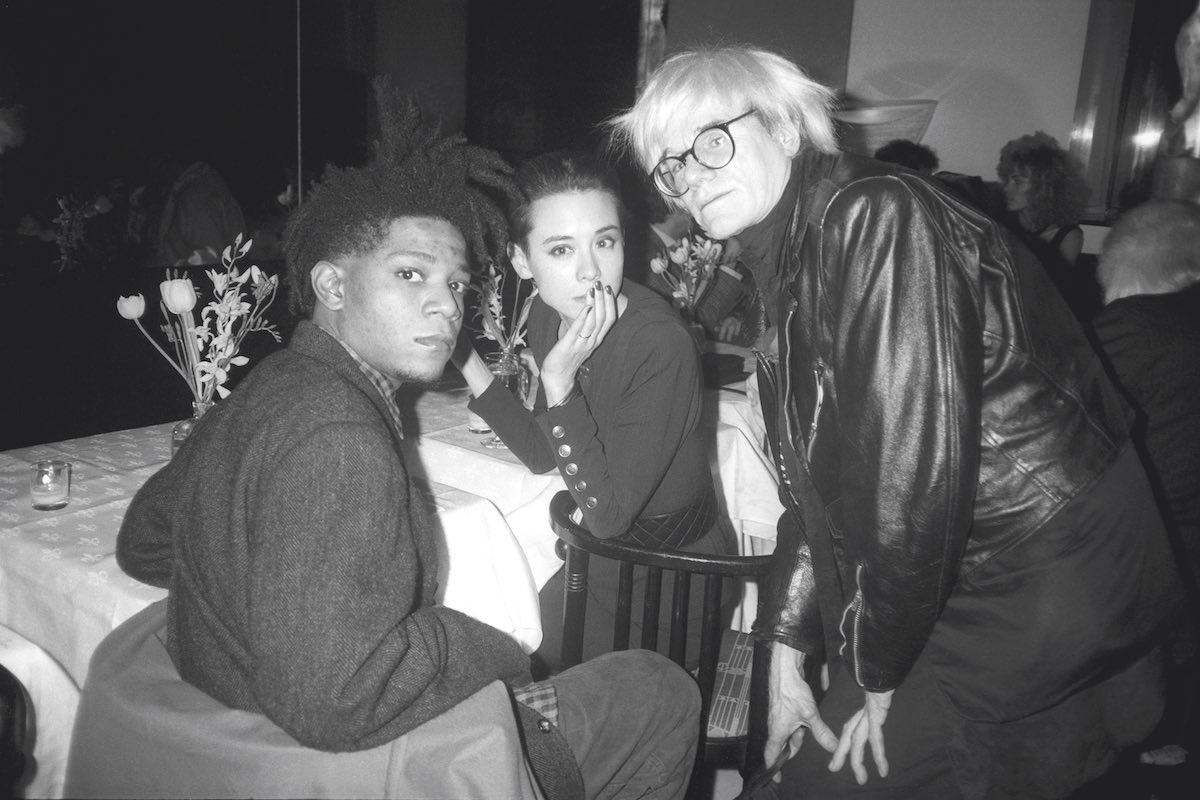 Tina Chow dining with Jean-Michel Basquiat and Andy Warhol, 1986 (Photo by Patrick McMullan/Getty Images)