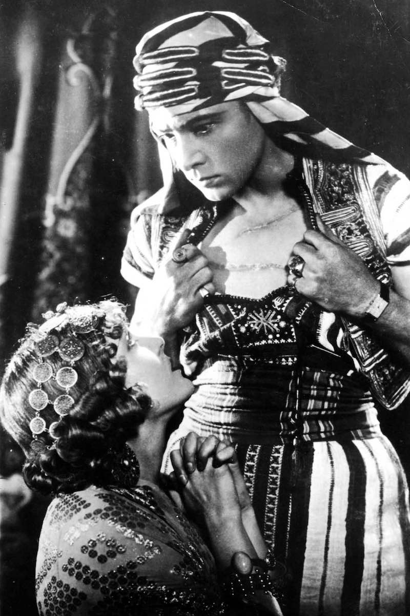 Vilma Banky and Rudolph Valentino in the 1926 film, Son of the Sheik; Valentino insisted on wearing his treasured Cartier Tank during the filming. In every scene. The issue with his decision is that the Tank is not a timepiece that would've a reality in the period in which the film is based