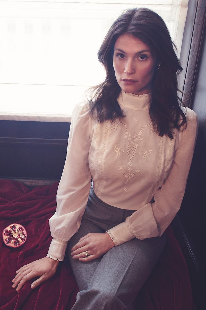 White organic cotton Tennyson open-back broderie anglaise blouse, Reformation; grey flannel high-waisted flare trousers, Caroline Andrew; white-gold 18-carat and diamond droplet earrings, Meváris. Rings, property of Gemma Arterton