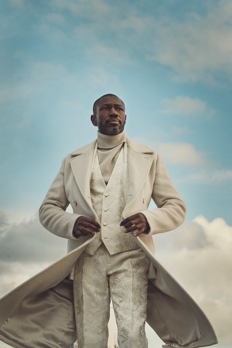 White virgin wool overcoat, white Jacquard trousers and vest, white roll-neck, all Dolce & Gabbana.