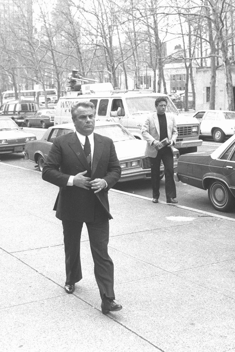 Gotti buttoning his double-breasted suit as he arrives at Brooklyn Federal Court, 1986 (Photo by NY Daily News Archive via Getty Images)