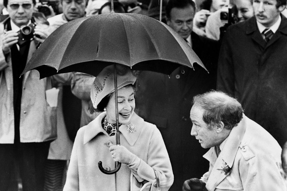 The Queen appears to be asking Canadian Prime minister Pierre Trudeau to share her umbrella in 1977 (Photo by Jeff Goode/Toronto Star Via Getty Images)