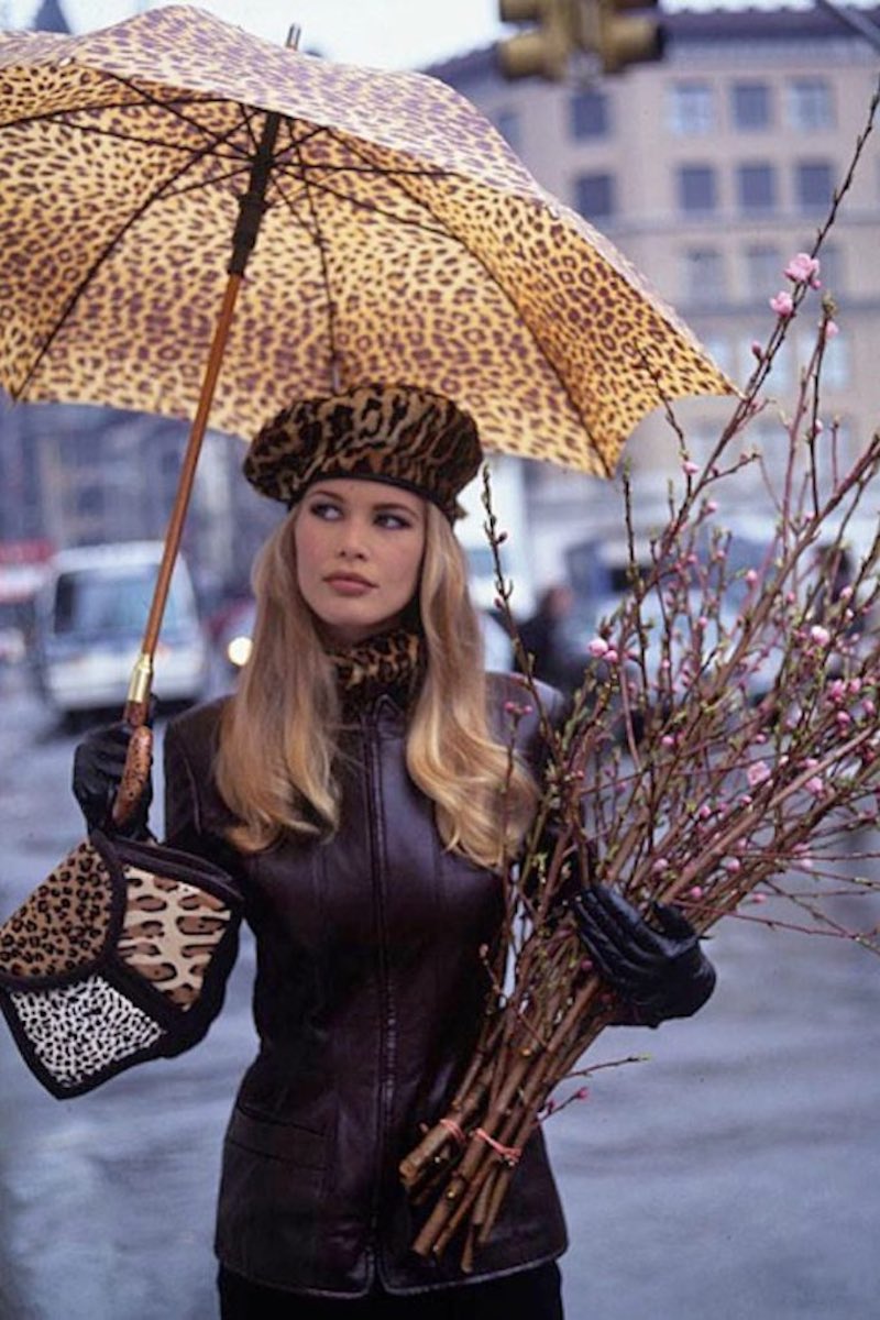 Claudia Schiffer, standing beneath leopard umbrella wearing leather jacket by Louis Dell'Olio for Anne Klein Collection - taken a Union Square Park, Greenmarket in New York City. (Photo by Arthur Elgort/Conde Nast via Getty Images)