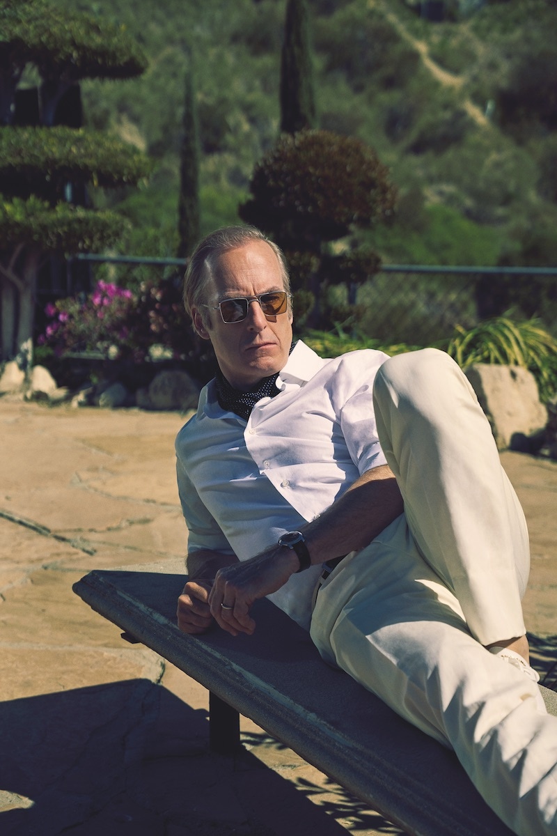 Ivory linen jacket, matching trousers and white cotton shirt, Brioni; white sneakers, Dolce & Gabbana; sunglasses, Jacques Marie Mage. Watch and wedding ring, property of Bob Odenkirk. Black spot silk scarf and black belt, stylist’s own.