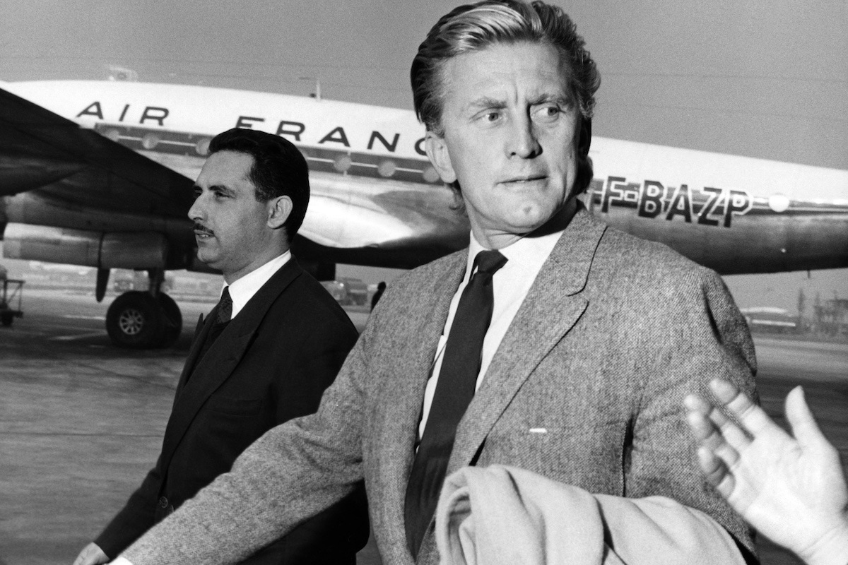 Kirk Douglas arrives at Orly airport, south of Paris, in 1957. (Photo AFP via Getty Images)