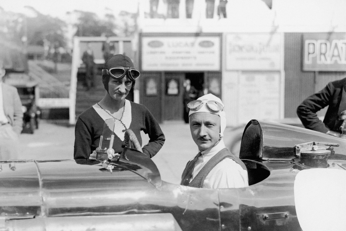 Sir Henry Birkin sits in his Blower Bentley and talks with Mrs Elsie Wisdom. (Photo by Barratts/PA Images via Getty Images)