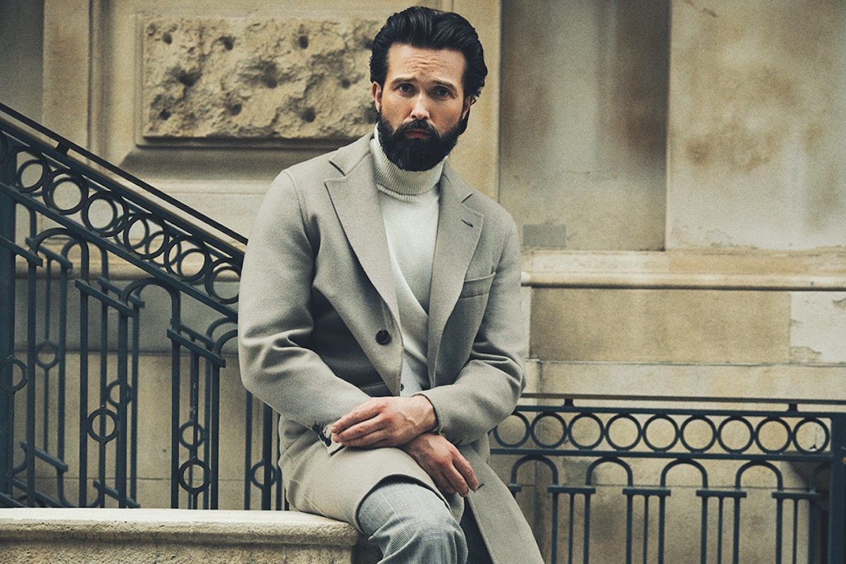 Beige Solferino virgin wool and cashmere overcoat, Brioni; pure white cashmere rollneck, Canali; grey wool oversized Blake check Aleksandar pleated trousers, Kit Blake; black vegan grain Fred boots, Grenson.