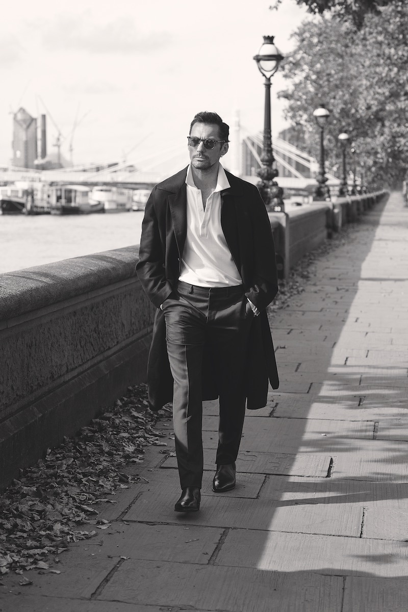 Navy cotton trenchcoat and midnight blue wool trousers, Brioni; off-white 100% cotton sweat polo, David Gandy Wellwear; brown leather Chelsea boots, George Cleverley; Tatah Sun sunglasses, MOSCOT. Br 03-92 Golden Heritage, 42mm case, Bell & Ross