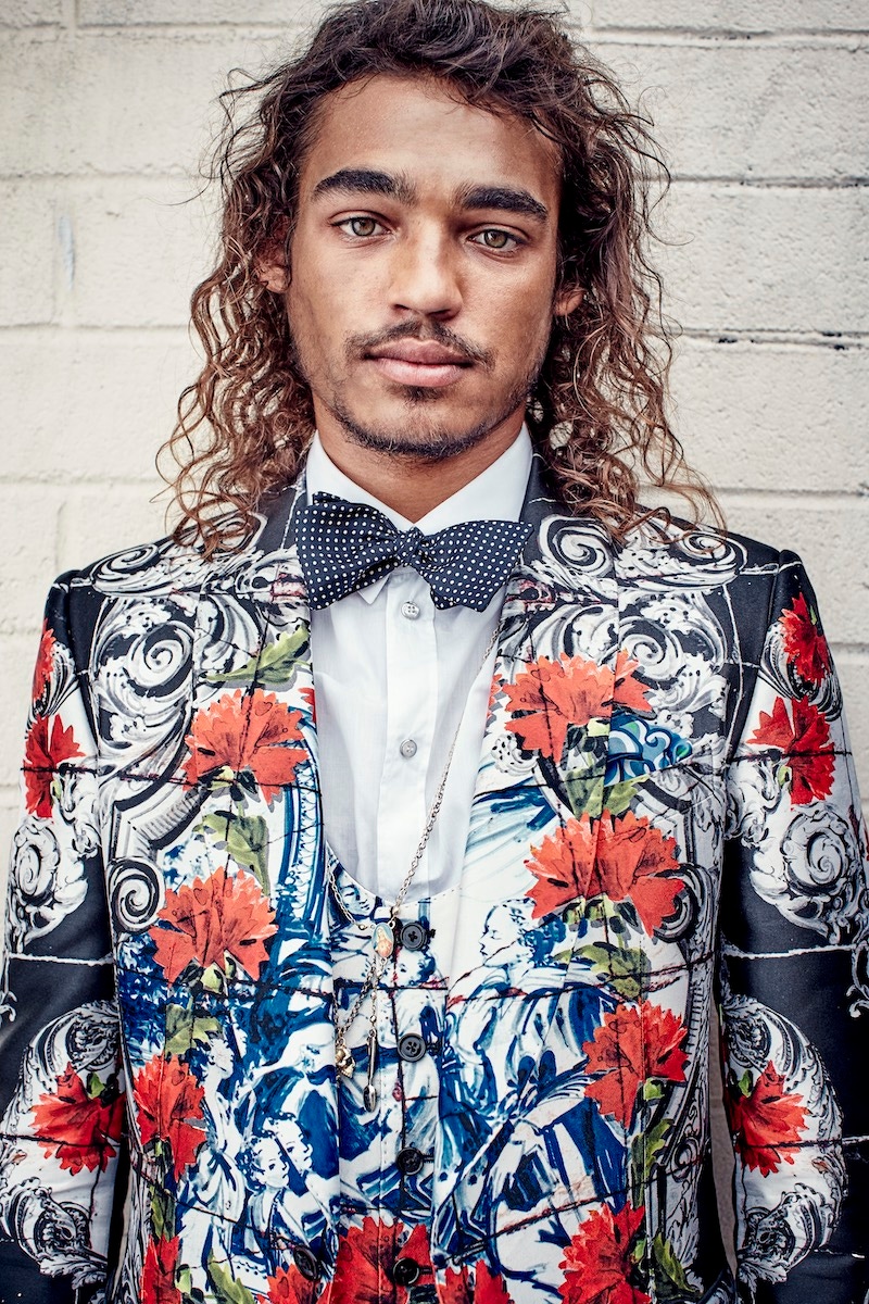 Black and white rose-printed wool and silk three-piece evening suit, white cotton shirt, both Dolce & Gabbana; black silk spotted bow tie, Budd Shirtmakers; blue patterned silk pocket handkerchief, Drakes. Gold chains, property of the skater.