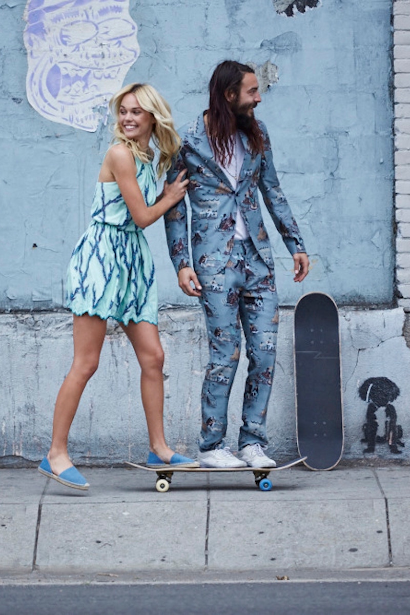 RAF-blue printed silk suit, Valentino, ivory cashmere-silk lightweight knitted T-shirt, Canali. White canvas trainer, Vans, property of the skater. On her: Cyan dress, Louis Vuitton, leopard-print blue pumps, Jimmy Choo.