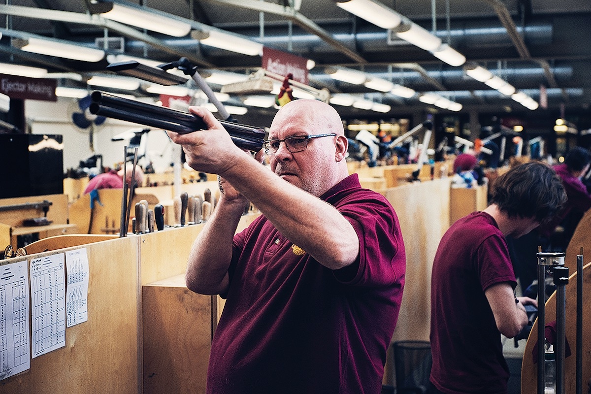 An experienced barrel maker inspects the work