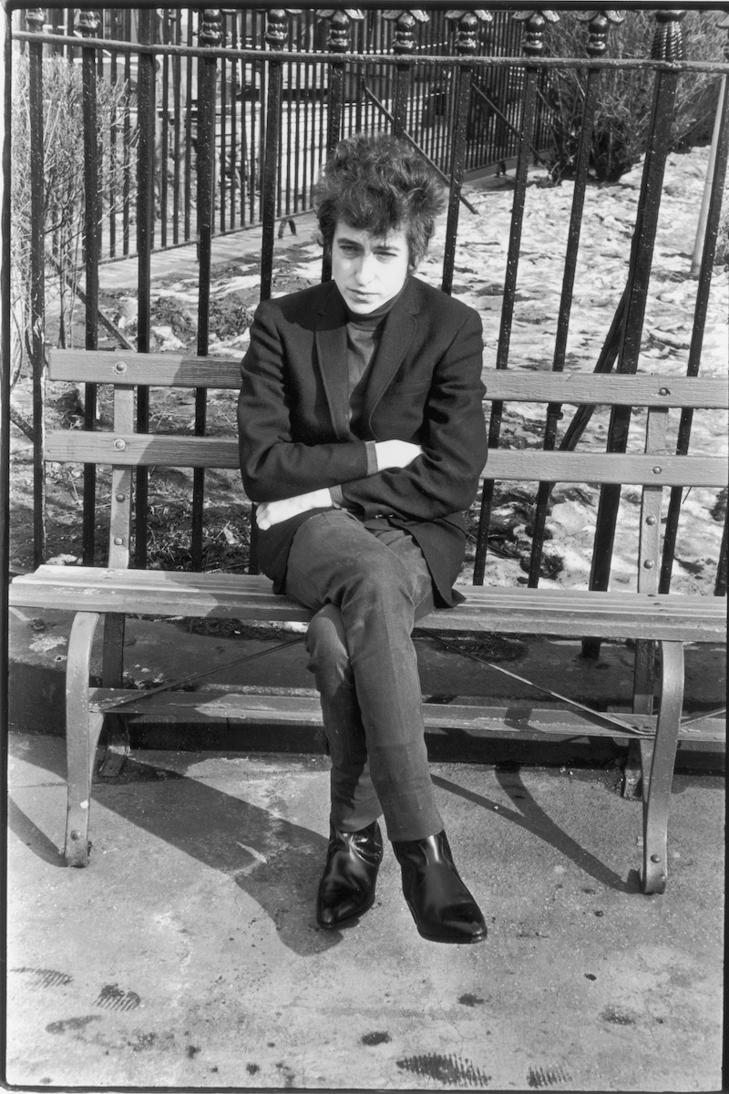 American musician Bob Dylan (born Robert Zimmerman) sits on a bench in Sheridan Square Park, New York, 1965. (Photo by Fred W. McDarrah/Getty Images)