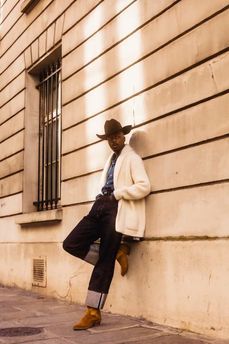 Kevis wears: blue cotton denim shirt, Lorenzo Cifonelli for The Rake; white shawl cardigan, Anderson & Sheppard; hat, denim and boots, models own.