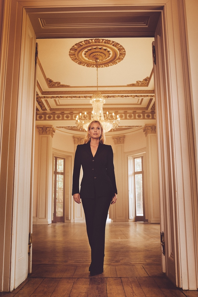 Eliza: Black crêpe wool bespoke suit, Caroline Andrew; Jacqueline heels, Di Minno; earrings from The Happy Diamonds collection featuring two dancing diamonds and diamond pavé set in 18-carat white-gold, Chopard.