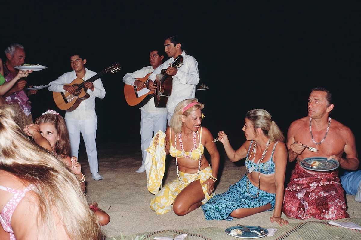 Dinah Shore (centre) and Kirk Douglas (far right) at a beach party, 1968. (Photo by Slim Aarons/Hulton Archive/Getty Images)